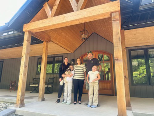 happy family in front of their new home